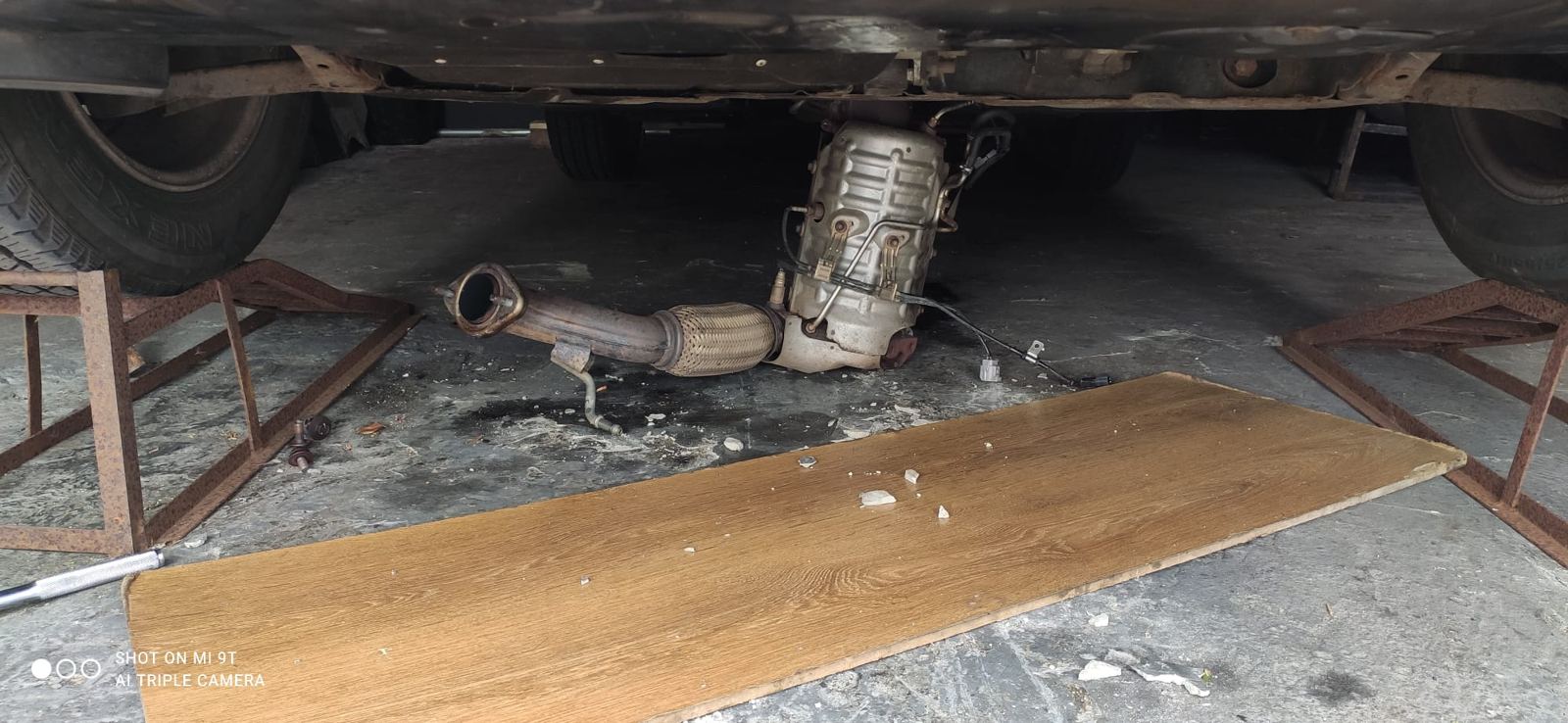 DPF being removed from underneath a car